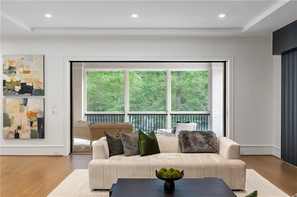 Sliding doors disappear into the walls and open to a screened in porch with beautiful tree lined view of your property