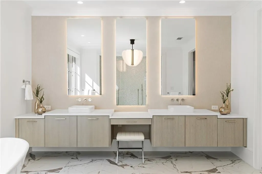 Primary bath suite showcases stunning marble finishes, floating custom cabinets and designer lighting.