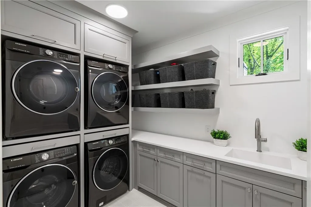 Two washer and dryers, custom cabinetry, shelving and sink for your convenience on the second level