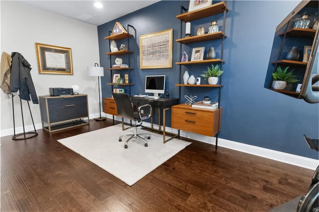 Home office with dark hardwood / wood-style floors