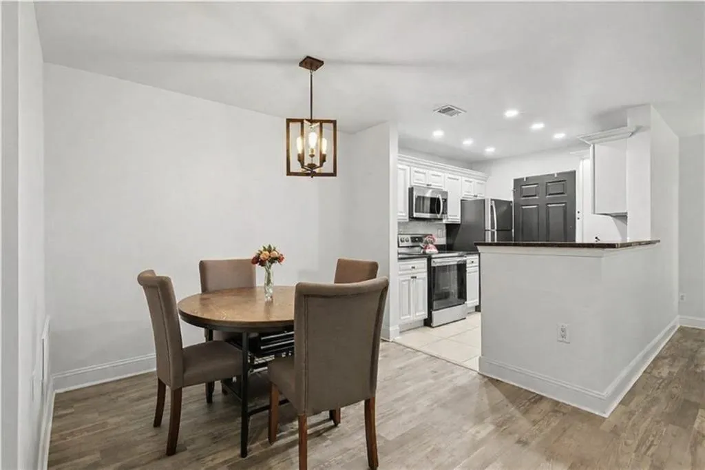 Dining room with light wood finished floors and hanging lights