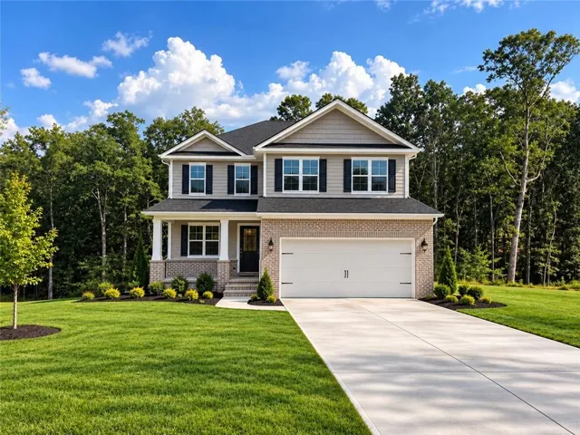 Two-story residence featuring a brick facade, covered entry porch with columns, attached two-car garage, and a concrete driveway