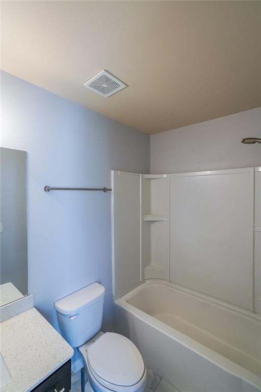 Full bathroom with vanity, toilet, tile floors, and  shower combination