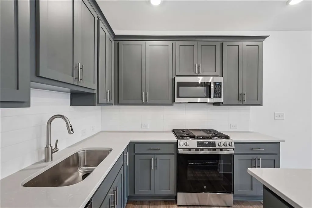 Elevated Kitchen with 42" Gray Cabinets, Quartz Countertops, Pendant Lighting, and Single Bowl Sink