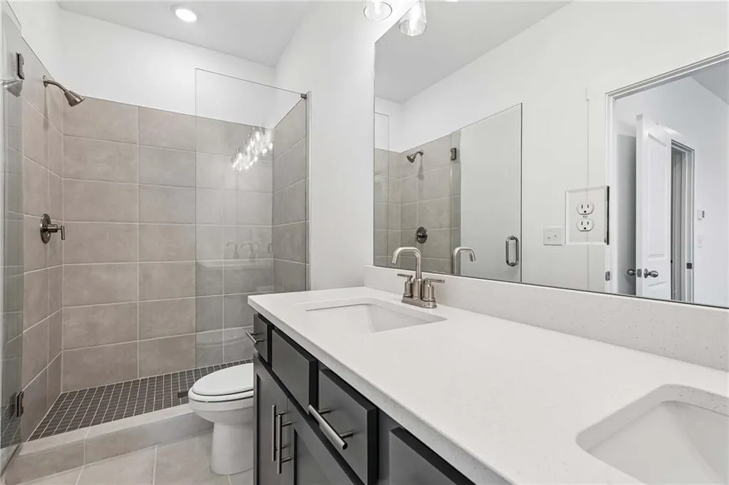 Spa-like with Double Vanity Sinks, Tile Shower with Frameless Doors, and Tile Flooring