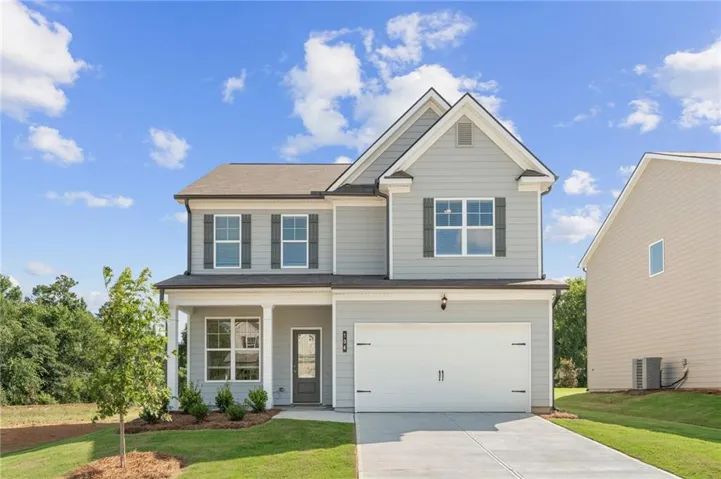 Two-story residence featuring light gray siding with dark gray shutters, a covered porch entry, an attached two-car garage, and a concrete driveway