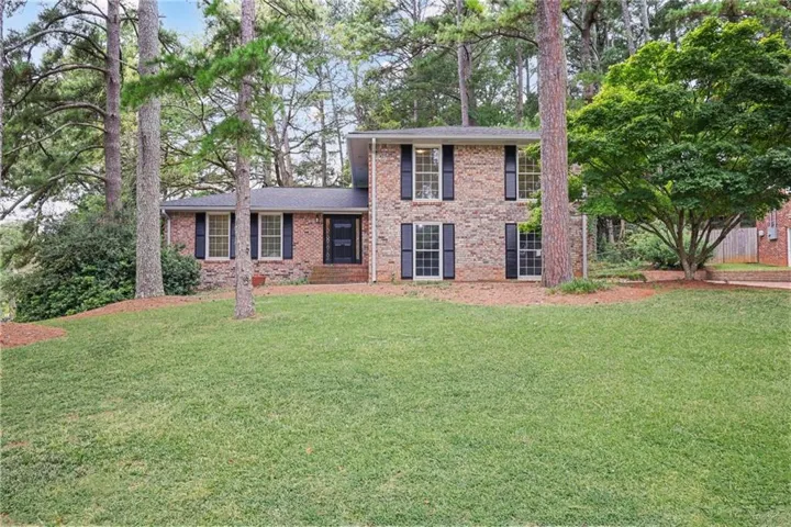 Brick exterior, mature trees, front lawn, front entry door, window shutters