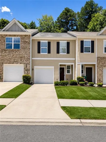 Multi-story townhouse exterior with a mix of brick and horizontal siding