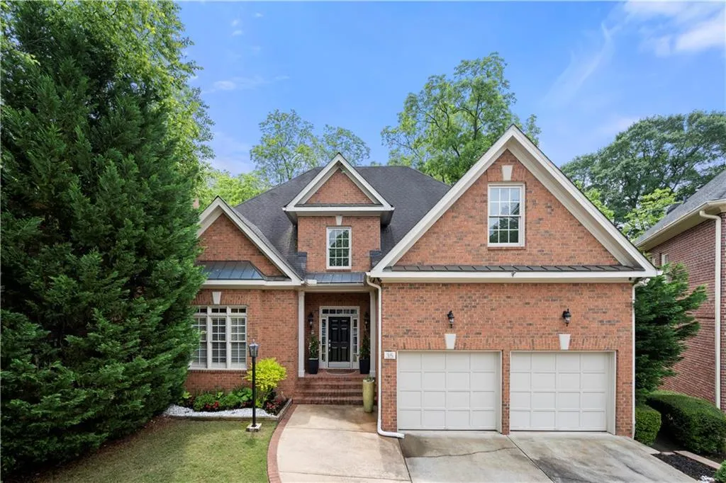 Traditional-style house featuring brick siding, concrete driveway, an attached garage, and a standing seam roof