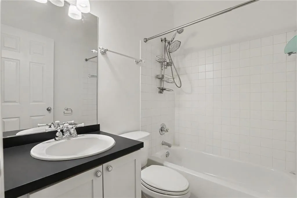 White vanity with a dark countertop and an undermount sink