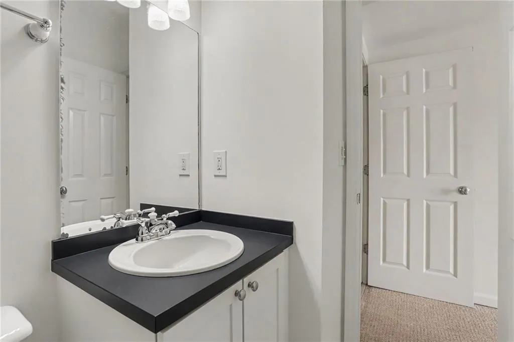 Built-in vanity with a black countertop and integrated oval sink