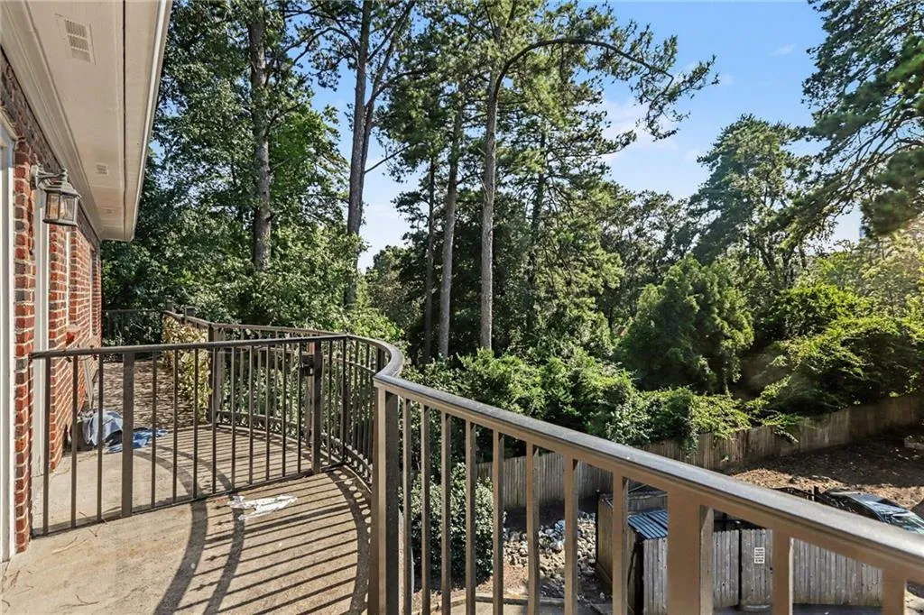 Curved balcony with metal railings and a concrete surface, providing an outdoor extension