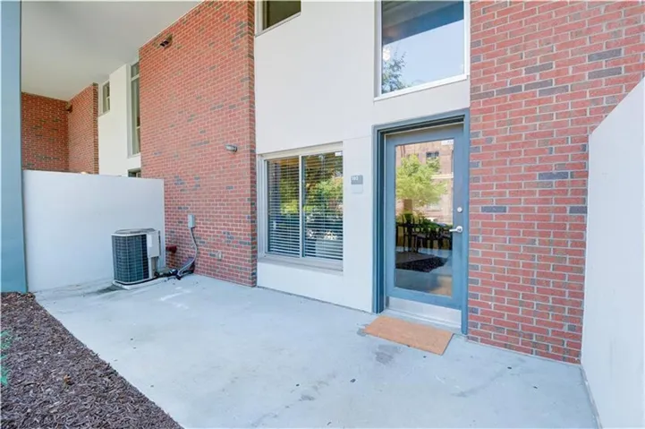 Doorway to property with a patio area and brick siding
