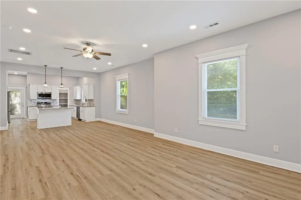 Unfurnished living room with light wood-style flooring, ceiling fan, and recessed lighting