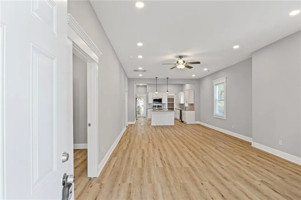 Unfurnished living room featuring plenty of natural light, ceiling fan, light wood-style floors, and recessed lighting