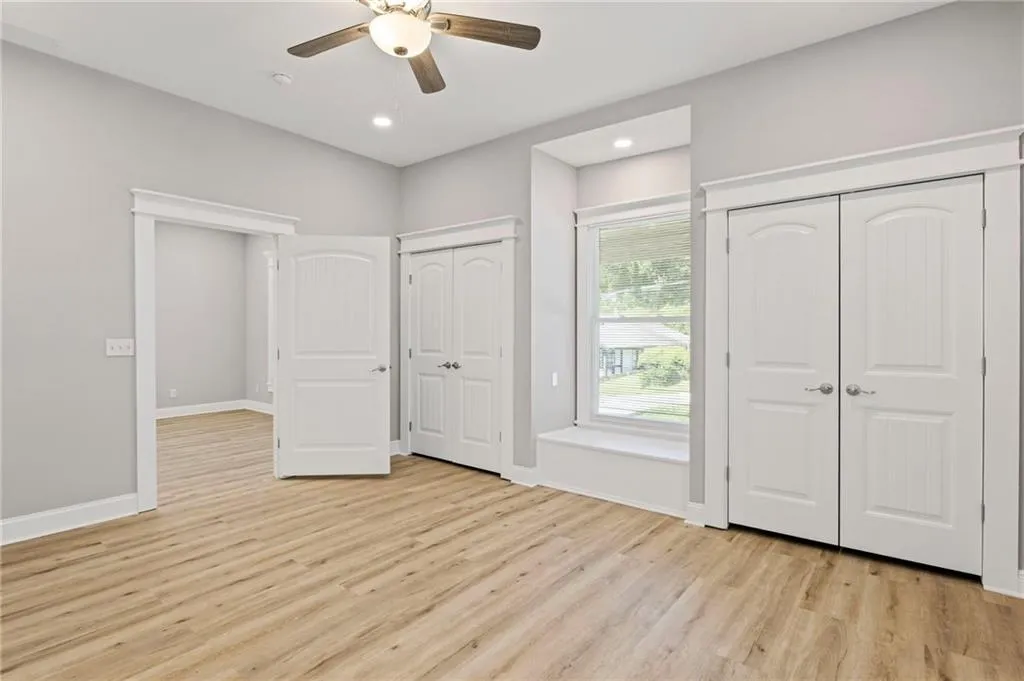 Unfurnished bedroom featuring two closets, light wood-style floors, recessed lighting, and ceiling fan