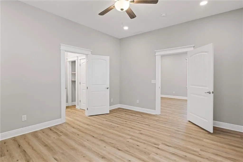 Unfurnished bedroom with light wood-type flooring, recessed lighting, a walk in closet, and ceiling fan