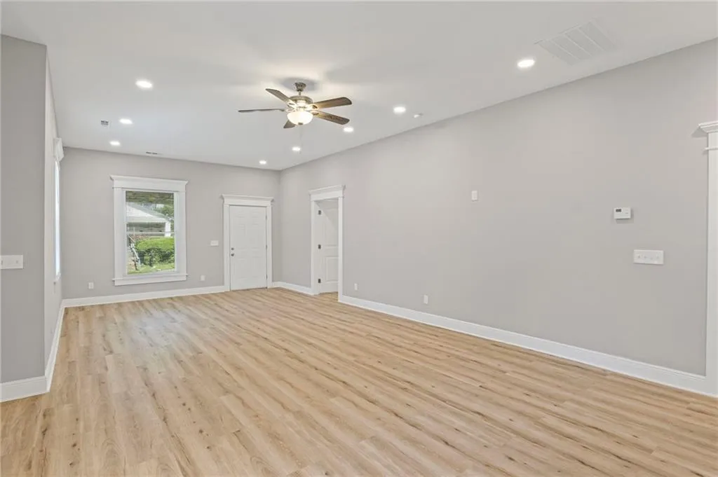 Empty room featuring ceiling fan, light wood finished floors, and recessed lighting