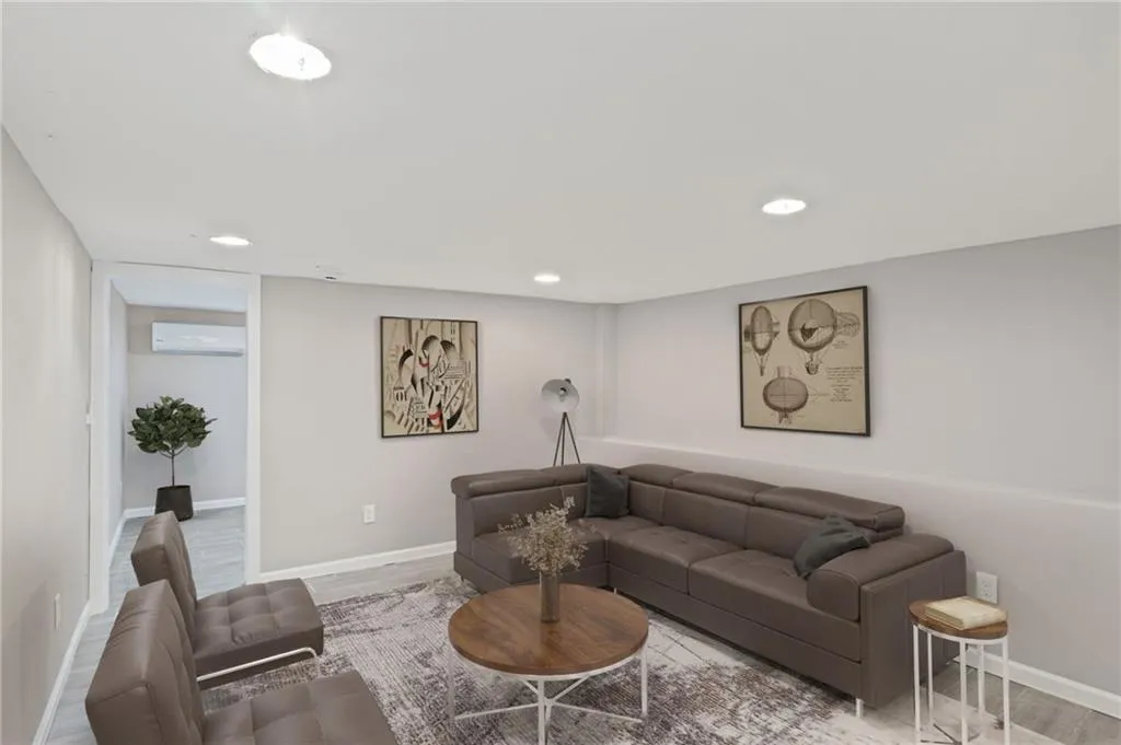 Virtually Staged-Living area featuring wood finished floors, recessed lighting, and a wall mounted AC