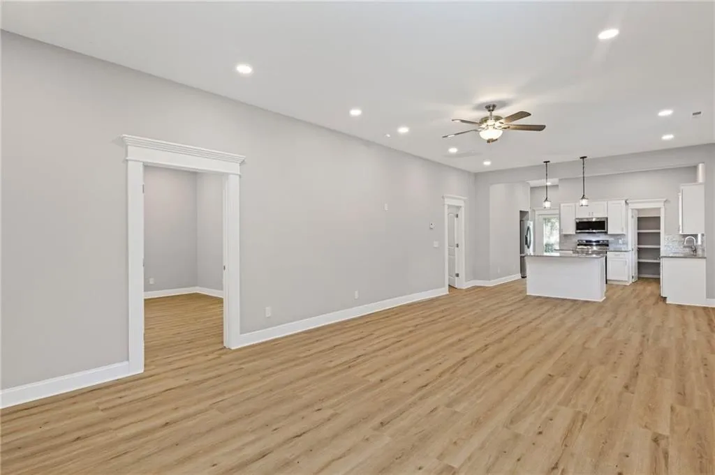 Unfurnished living room featuring ceiling fan, recessed lighting, and light wood finished floors