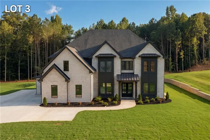 Contemporary residence featuring a light brick exterior and dark trim accents