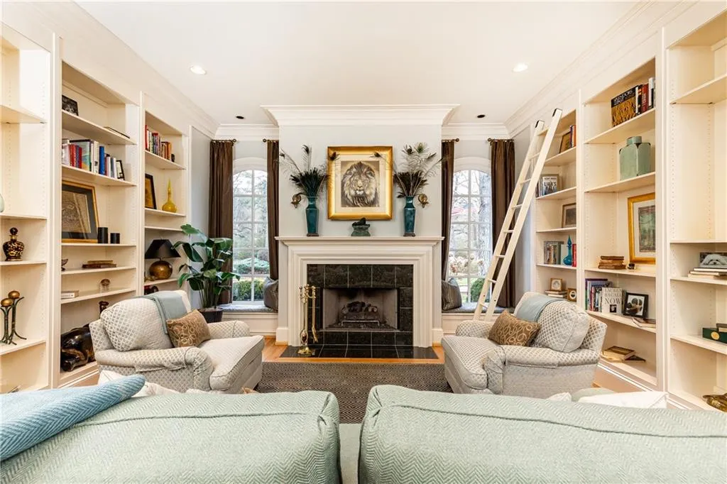 Living Room/Study with gas-log fireplace and built-in book/display cases.