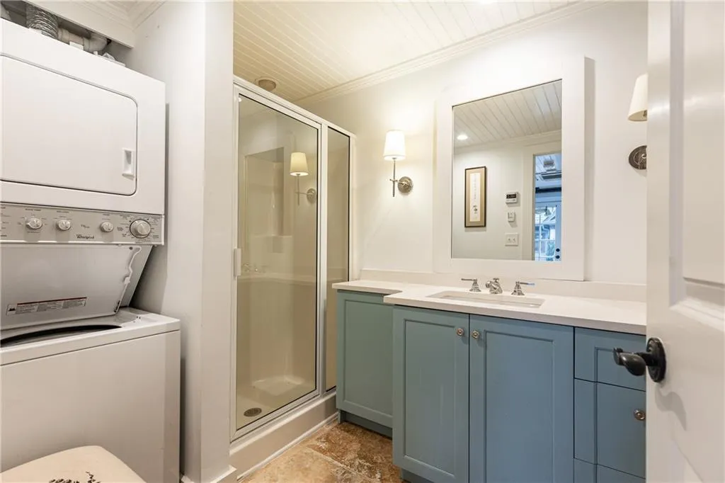 Guest House Bath with shower and stacked washer/dryer.