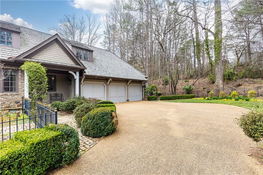 Side of home featuring a pea gravel driveway, covered side entry to house and entry to 3-car garages.