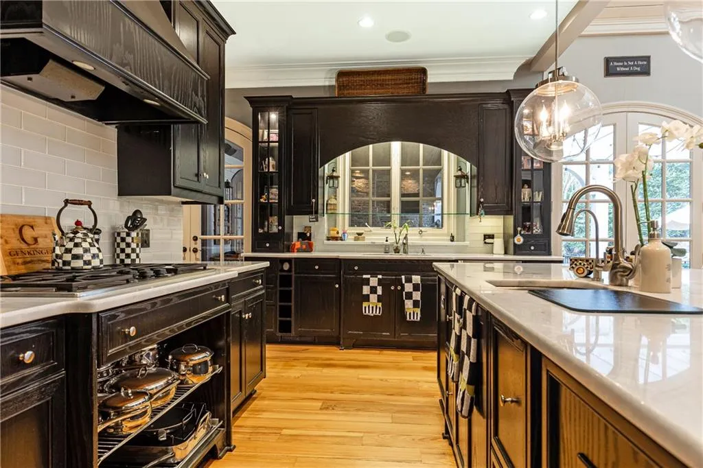Appliances include Dacor 5-burner gas cooktop and warming drawer, Sub-Zero refrigerator/freezer, Bosch microwave and dishwasher and double Monogram ovens.