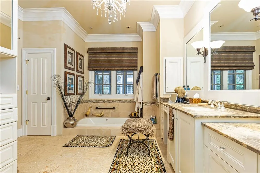 Luxurious Primary Bath offers a sunken soaking tub and private areas on either side of a central shower.
