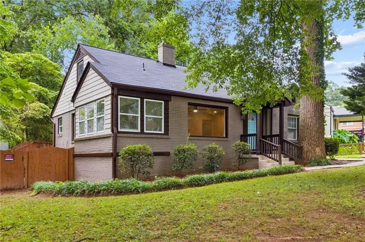 Single-story brick residence featuring a charcoal shingle roof and a prominent front gable with light-colored siding