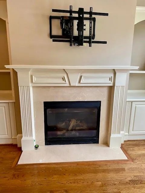 Detailed view of a fireplace and wood finished floors