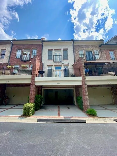 View of front facade with brick siding and a balcony