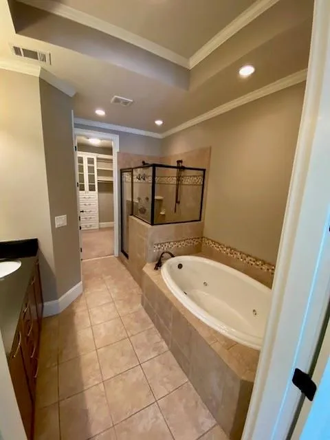 Bathroom featuring a tub with jets, vanity, a shower stall, light tile patterned flooring, and recessed lighting