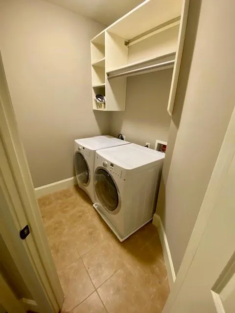 Washroom featuring light tile patterned floors and washing machine and clothes dryer