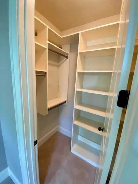Walk in closet featuring dark colored carpet