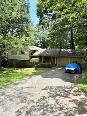 Ranch-style residence featuring a split-level design, an attached two-car garage, and a concrete driveway
