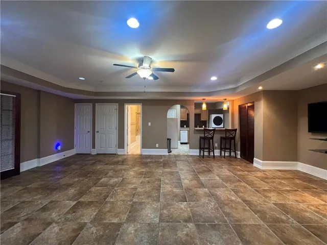 Spacious room featuring large format tile flooring, crown molding, and recessed lighting