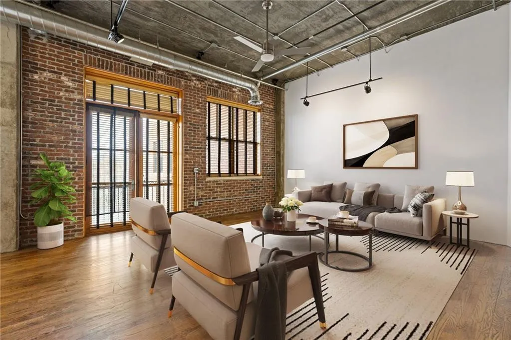 Living area with brick wall and hardwood / wood-style flooring