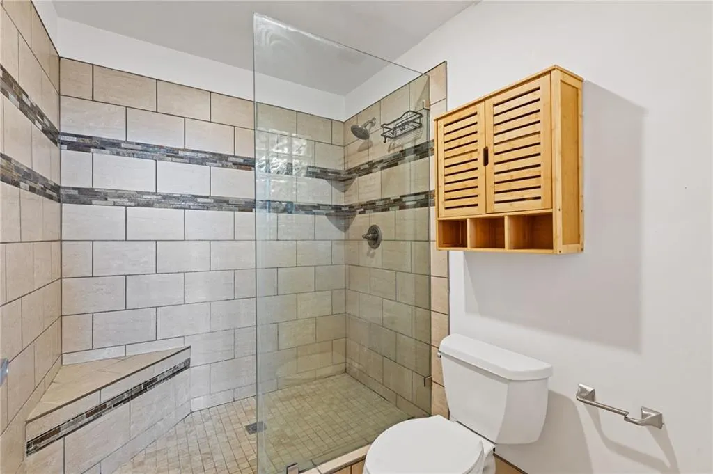 Full bathroom with toilet and walk in shower