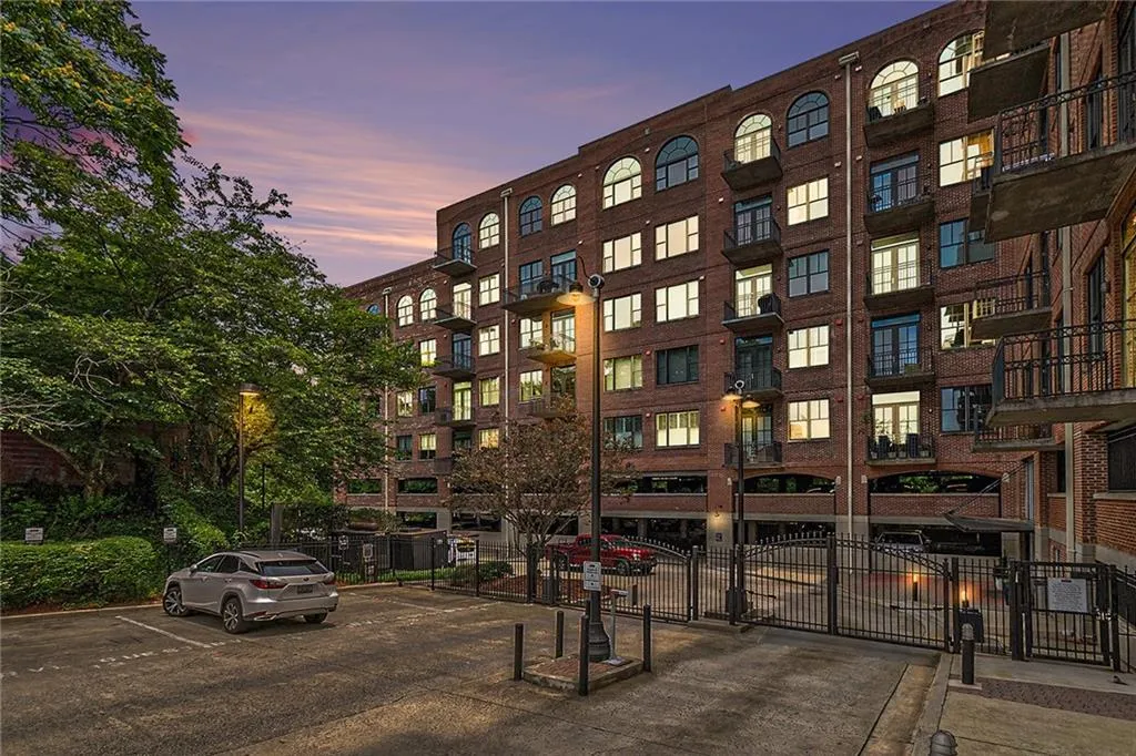 Property at dusk with a view of apartment building / complex and uncovered parking