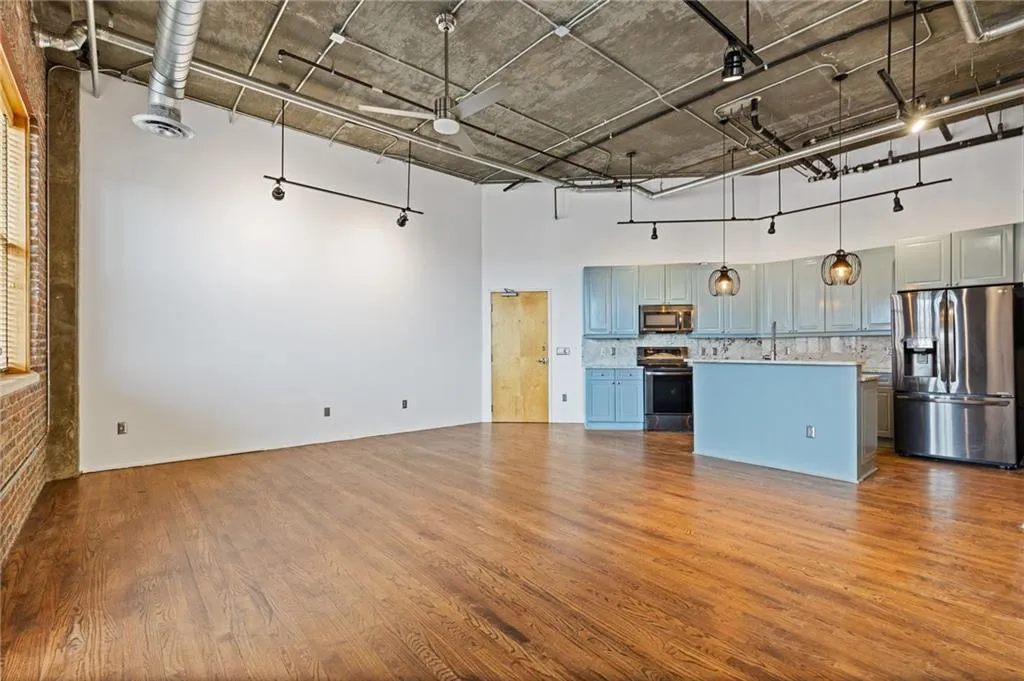Unfurnished living room with dark wood finished floors and a high ceiling