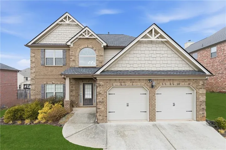 Brick exterior with stone-look accents and a two-car garage