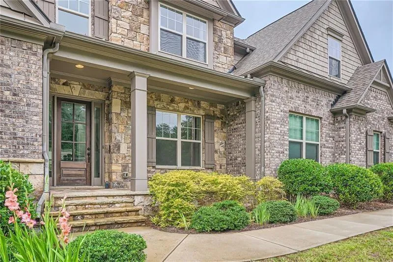 View of exterior entry with a porch and stone siding