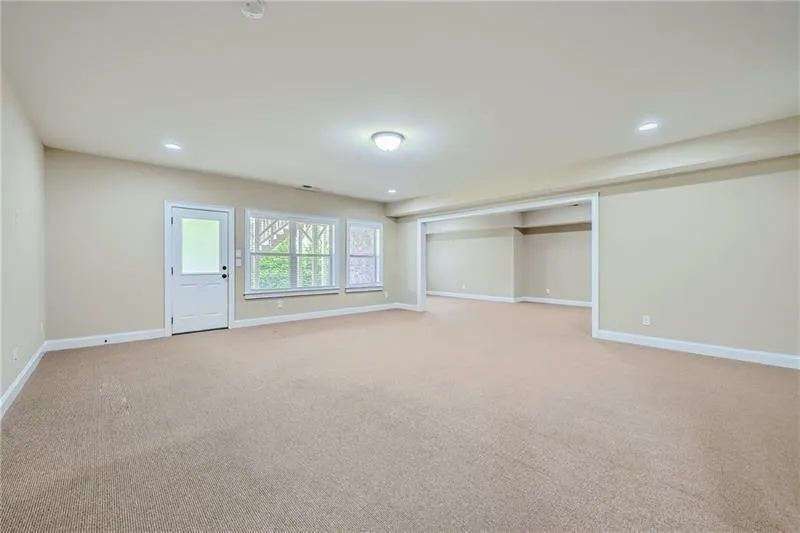 Basement with recessed lighting and light colored carpet