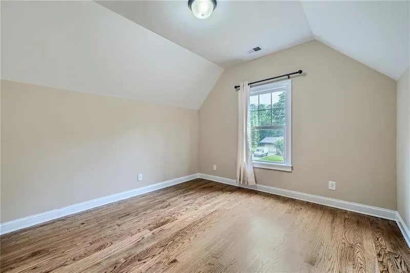 Additional living space with vaulted ceiling and light wood-type flooring