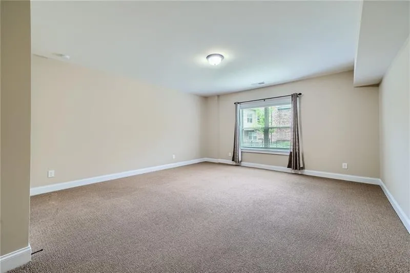 Unfurnished room featuring baseboards and light colored carpet