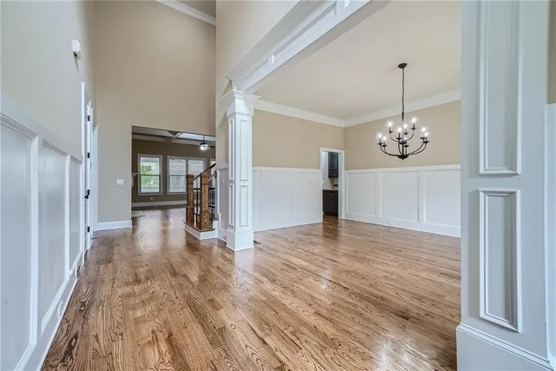 Foyer entrance featuring ornamental molding, ornate columns, a decorative wall, stairs, and ceiling fan
