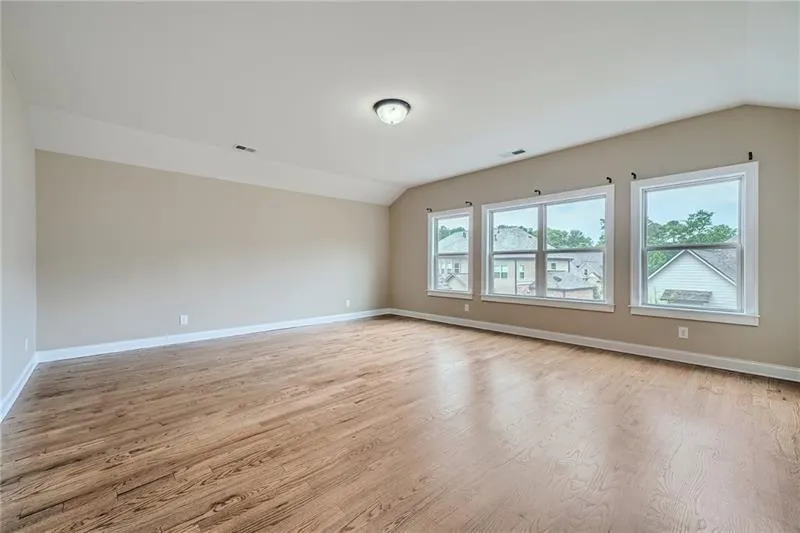 Empty room featuring vaulted ceiling and light wood-style flooring
