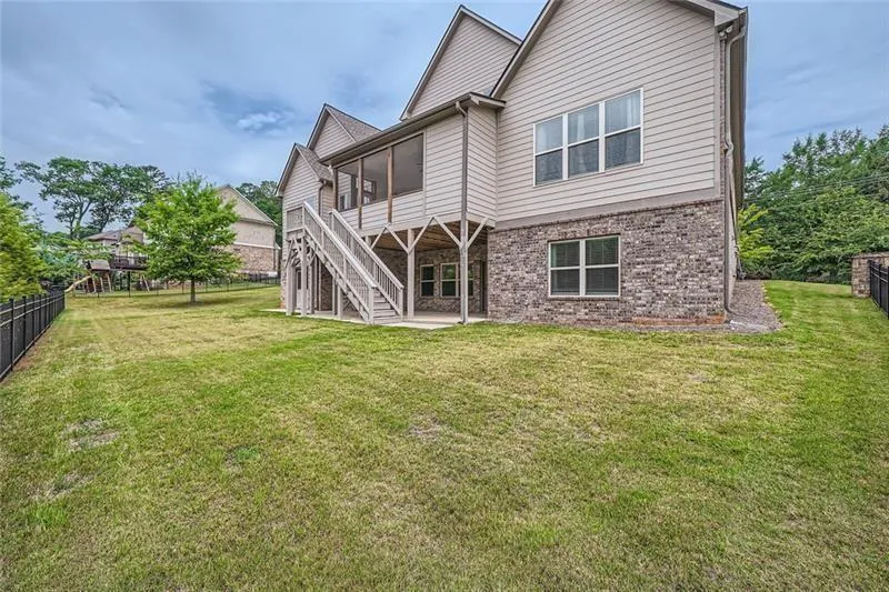 Back of house with a patio, brick siding, stairs, and a sunroom